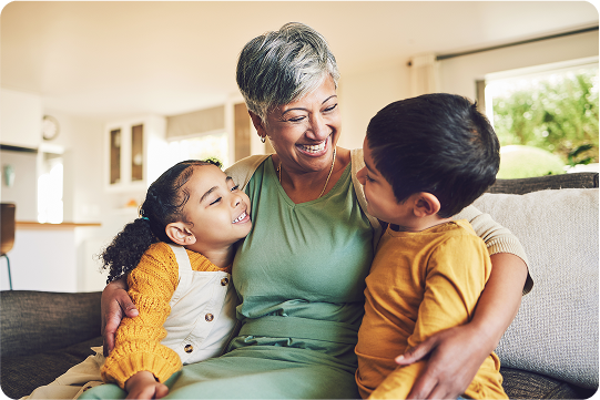 Senior holding grandchildren and smiling