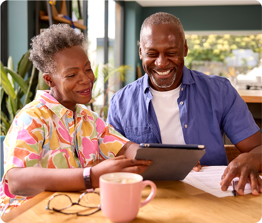 Seniors sitting at the dinner table in the morning signing up for Medicare Advantage while drinking coffee